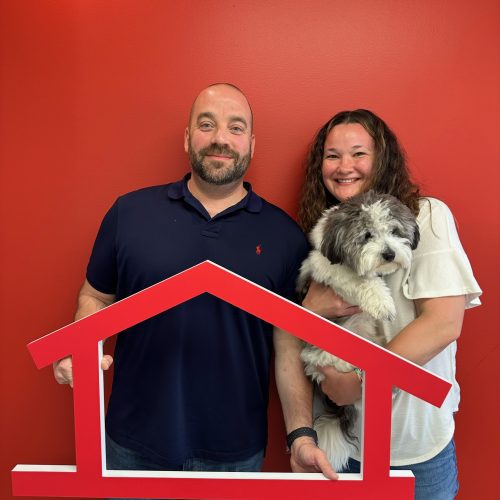 Happy homeowners holding a dog
